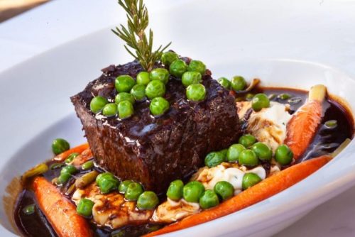 Plated steak with peas and carrots