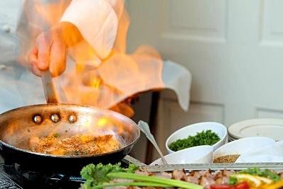 Chef flambé scampi in a pan